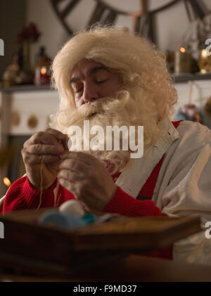 Travailler à la maison du Père Noël. La réparation de ses gants Banque D'Images