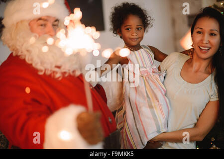 Santa Claus surprenant petite fille et sa mère à la maison Banque D'Images