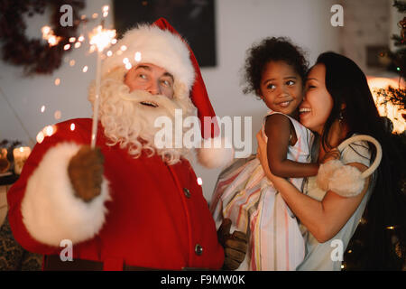 Santa Claus surprenant petite fille et sa mère à la maison Banque D'Images