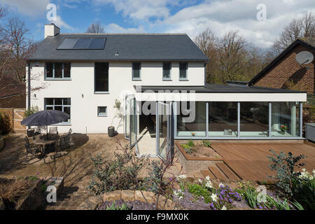 Arrière de la maison avec des panneaux solaires et d'une télévision extension couverte avec des murs de verre. Banque D'Images