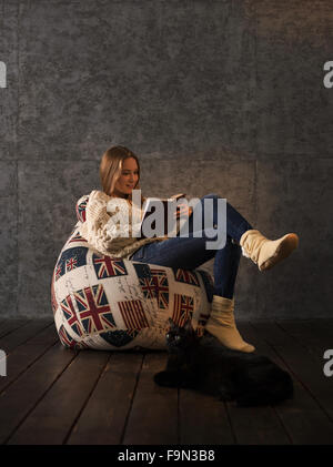 Girl Studying on Pouf poire à la maison Banque D'Images