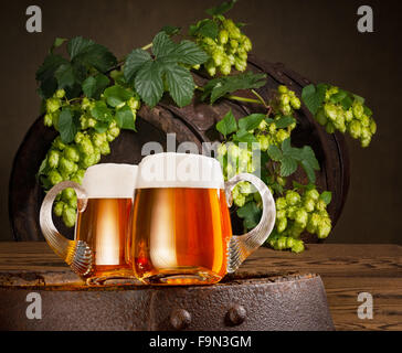 Deux verres de bière au houblon sur le tonneau en bois ancien Banque D'Images