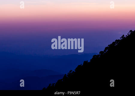 Silhouette de versant de montagne Tajumulco avec arbres devant rose violet bleu coucher soleil Banque D'Images