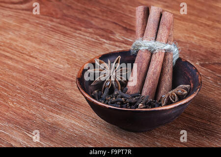 Les épices de Noël traditionnel - l'anis étoilé, de girofle et cannelle écorce bois - sur une table en bois Banque D'Images
