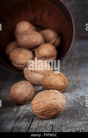 Les noix en cuvette d'argile sur table en bois Banque D'Images