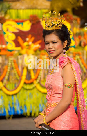 Reine de beauté féminine dans une robe traditionnelle Rose and Crown marchant dans le défilé au centre-ville de flottement avant d'éléphants à Surin Banque D'Images