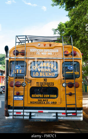 Arrière d'un autobus scolaire jaune garée dans la rue avec des lettres sur elle Banque D'Images