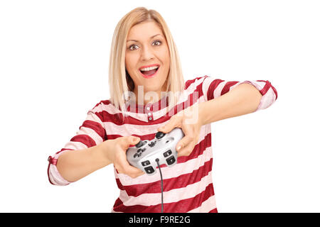 Jeune femme enthousiaste à jouer aux jeux vidéo avec une manette et regardant la caméra isolé sur fond blanc Banque D'Images