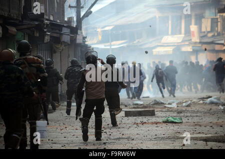 Srinagar, Inde. Dec 18, 2015. Les policiers indiens chasser les manifestants dans le vieux Srinagar, la capitale d'été du Cachemire sous contrôle indien. Des affrontements éclatent dans la lutte contre l'Inde de nombreuses parties de la vieille ville de Srinagar peu après la prière du vendredi s'est terminé en congrégation grande mosquée. La police a utilisé des gaz lacrymogènes, des grenades assourdissantes et des balles en caoutchouc pour disperser les manifestants en colère. Credit : Faisal Khan/Pacific Press/Alamy Live News Banque D'Images