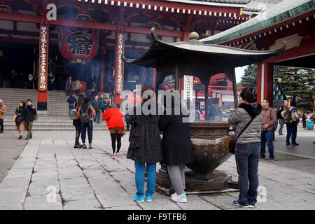 Des personnes se préparant à entrer dans le hall principal au Temple Bouddhiste Senso-ji, Asakusa, Tokyo, Japon Banque D'Images