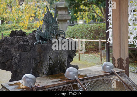 Un dragon fontaine à eau et des louches, pour laver vos mains avant d'entrer dans un temple Shinto, Japon Banque D'Images