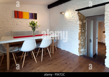 Salle à manger de style contemporain dans une ancienne maison rurale, peint en blanc des murs en pierre. Banque D'Images