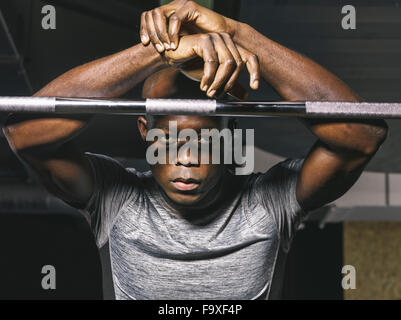 Portrait de l'athlète physique reposant sur barbell in gym Banque D'Images