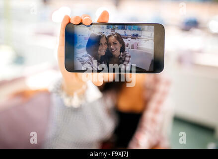 Deux des selfies female friends sur l'écran du téléphone cellulaire Banque D'Images
