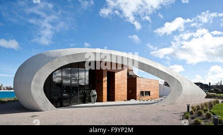 Une structure extérieure incurvée blanc dramatique autour d'un bâtiment qui offre des espaces sociaux et de traitement pour les patients atteints de cancer, dans le parc d'un hôpital. Les soins de santé. Banque D'Images