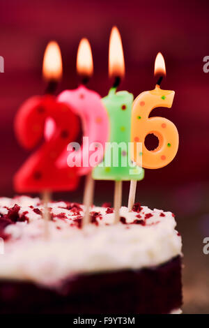 Libre de quatre allumé des bougies en forme de nombre de couleurs différentes formant le nombre 2016, comme la nouvelle année, sur un gâteau Banque D'Images