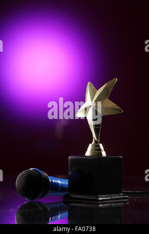 Trophée star et le microphone sur le fond violet Banque D'Images