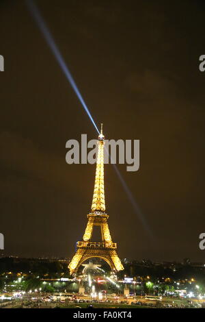 La tour Eiffel la nuit à la recherche de la lumière au bout de la tour en diagonale traîné à l'arrière-plan, et des canons à eau.. Banque D'Images