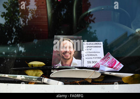 Madrid, Espagne 19 décembre 2015: Une notice électorale avec le visage du chef du parti Podemos Pablo Iglesias Turrión sous les essuie-glaces de voiture dans le centre de Madrid. L'Espagne tiendra des élections générales le 20 décembre, Podemos est un nouveau parti populiste de gauche officiellement fondé en mars 2014 qui est rapidement devenu l'un des partis les plus populaires en Espagne. Les autres papiers sont des annonces pour les appartements et l'immobilier à la vente. Banque D'Images