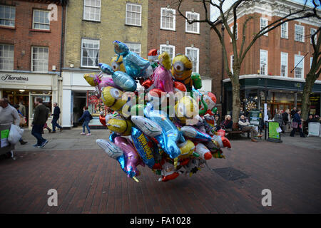 Les acheteurs de Noël devant un vendeur de rue vendant des ballons sur le dernier samedi avant le jour de Noël de Chichester, West Sussex, Angleterre. Banque D'Images