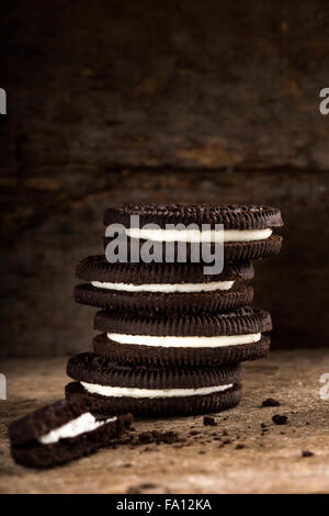 Les cookies au chocolat avec crème vanille garniture sur fond de bois Banque D'Images