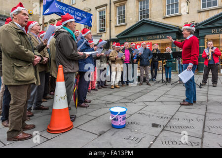 Bath, Royaume-Uni. Dec 19, 2015. Un choeur de divertir les clients, la collecte de fonds pour la maison de Dorothy Hospice Care charité, un jour de fortes averses dans la ville de Bath dans le Somerset sur 'la panique samedi". Credit : Terry Mathews/Alamy Live News Banque D'Images