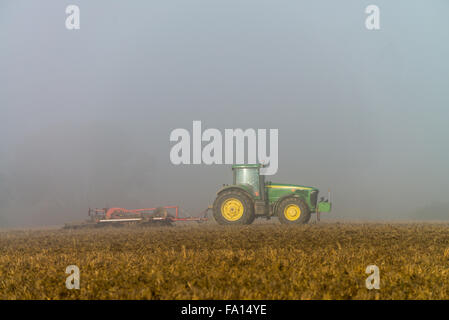 Dans le domaine du tracteur dans le brouillard, Moravie, République tchèque, l'Union européenne, l'Europe. Banque D'Images