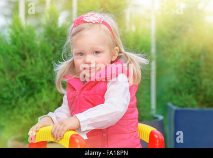 Portrait de petite fille blonde s'amuser sur l'aire de jeux dans chaude journée ensoleillée, adorable Enfant jouant à l'extérieur Banque D'Images