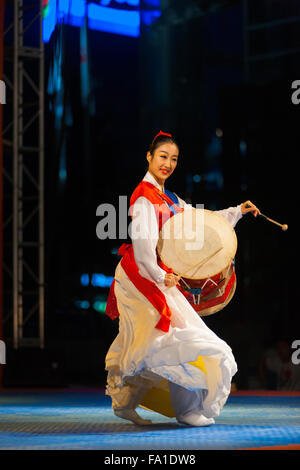 Belle femme coréenne danser, jouer des tambours janggu traditionnel en blanc et rouge hanbok en plein air nuit performance en été Banque D'Images