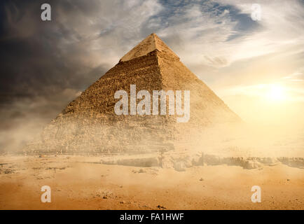 Pyramide dans la poussière de sable sous les nuages gris Banque D'Images