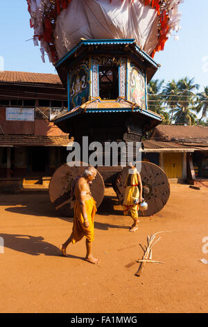 Deux prêtres brahmanes en passant devant le petit ratha char, un véhicule utilisé à Gokarna pour pleine lune fêtes hindoues Banque D'Images