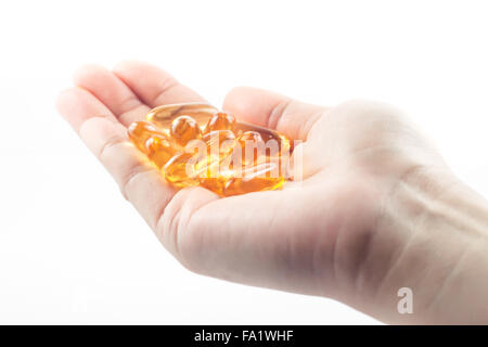 Main tenant des capsules d'huile de poisson sur fond blanc, stock photo Banque D'Images