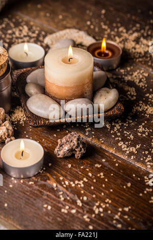 Belle composition avec des bougies et des pierres sur fond de bois Banque D'Images