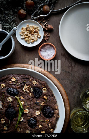 Méditerranée fête la farine de châtaigne Gâteau à plat blanc sur le plateau de table en bois avec des ingrédients, décoration de Noël, vin et gla Banque D'Images