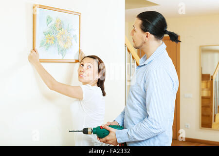 Couple d'âge moyen pour photo dans le mur à l'intérieur d'accueil Banque D'Images