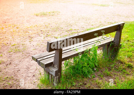 Vieux banc en bois sur la route de l'herbe en été Banque D'Images