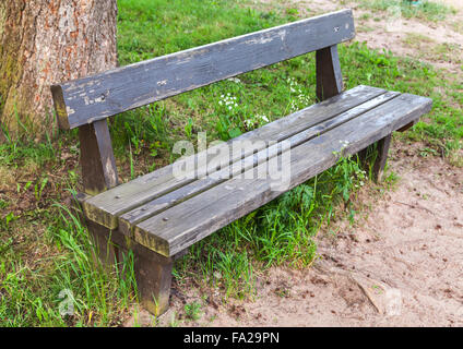 Vieux banc en bois, sur l'herbe en bordure du parc en été Banque D'Images