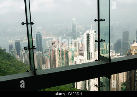 En regardant la ville asiatique de Hong Kong du Victoria Peak, à travers une fenêtre. Banque D'Images