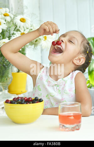 Cute Little girl eating cherries Banque D'Images