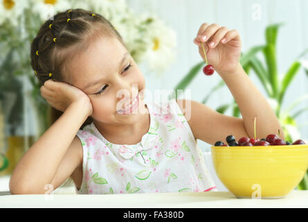 Cute Little girl eating cherries Banque D'Images