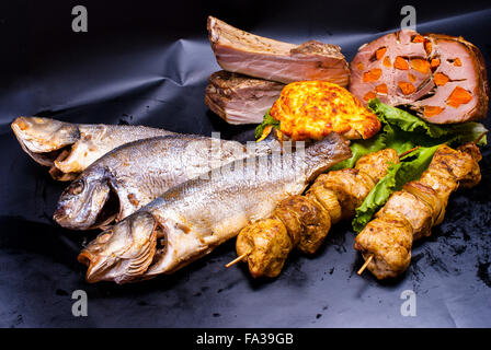 Still Life - avec la viande farcie, shish kebab, steak en pâte à crêpes, avec des remplissages, friture de poissons sur le fond noir Banque D'Images