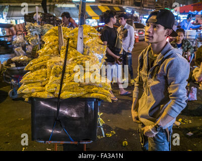 Bangkok, Bangkok, Thaïlande. Dec 21, 2015. Un vendeur de souci sur la rue en face de Pak Khlong Talat, aussi appelé le Marché aux Fleurs. Le marché a été un monument de Bangkok pendant plus de 50 ans et est le plus grand marché aux fleurs en gros à Bangkok. Une rénovation récente a donné lieu à de nombreux stands d'être fermé pour faire place à des chaînes de restaurants pour attirer les touristes. Les représentants de la ville de Bangkok maintenant menacent d'expulser les vendeurs de trottoir qui l'extérieur de la ligne de marché. L'éviction des vendeurs de trottoir est une partie d'un effort de la ville de ''nettoyer'' Bangkok. © Jack Kurtz/ZUMA/Alamy Fil Live News Banque D'Images