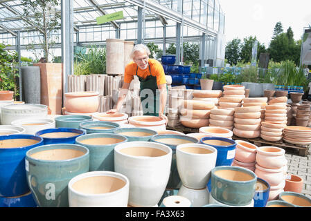 Jardinier homme organiser pots de céramique en serre, Augsbourg, Bavière, Allemagne Banque D'Images