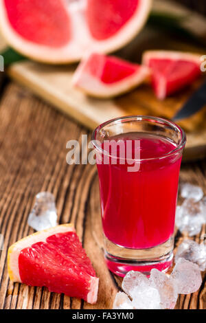 Verre à liqueur de pamplemousse sur fond de bois rustique Banque D'Images