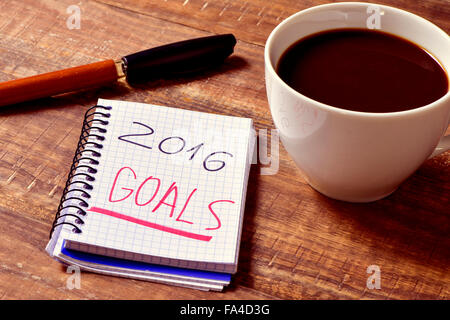 Libre d'un ordinateur portable avec le texte écrit en objectifs 2016 et une tasse de café sur une table en bois rustique Banque D'Images