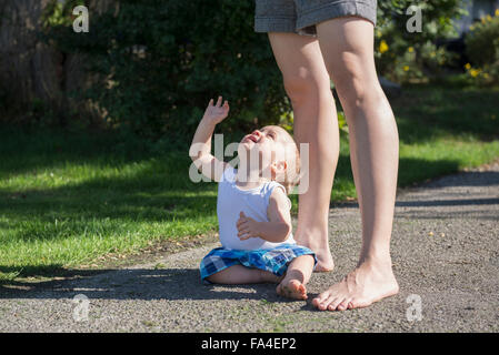 Bébé garçon assis sur le trottoir et demande à être élevé, Munich, Bavière, Allemagne Banque D'Images