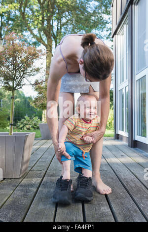 Baby Boy pas pour son père mère chaussures avec l'aide à lui, Munich, Bavière, Allemagne Banque D'Images