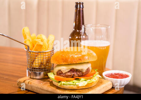 Un hamburger est servi avec de la salade et du fromage sur le dessus Banque D'Images