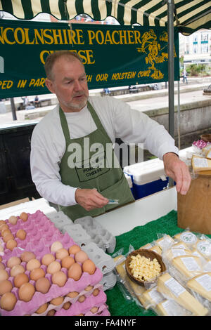 Exposant servant des produits locaux frais sur un fromage Lincolnshire Braconnier décrochage ; à un marché en plein air, Banque D'Images