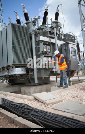 Un ingénieur électrique l'entretien du matériel à la Station Service Mtoni à Zanzibar, Tanzanie, Afrique de l'Est. Banque D'Images